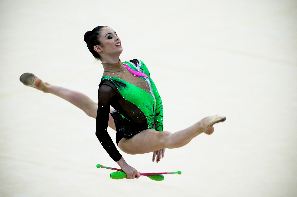 Laura Halford performs split leap with clubs